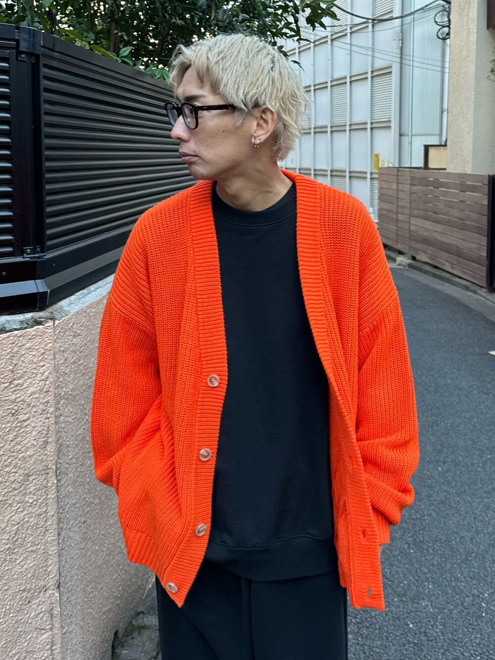 オレンジ系のカーディガン/ボレロ、ブラック系のスウェット、ブラック系のスウェットパンツを着用したメンズの冬コーディネートの3枚目の写真