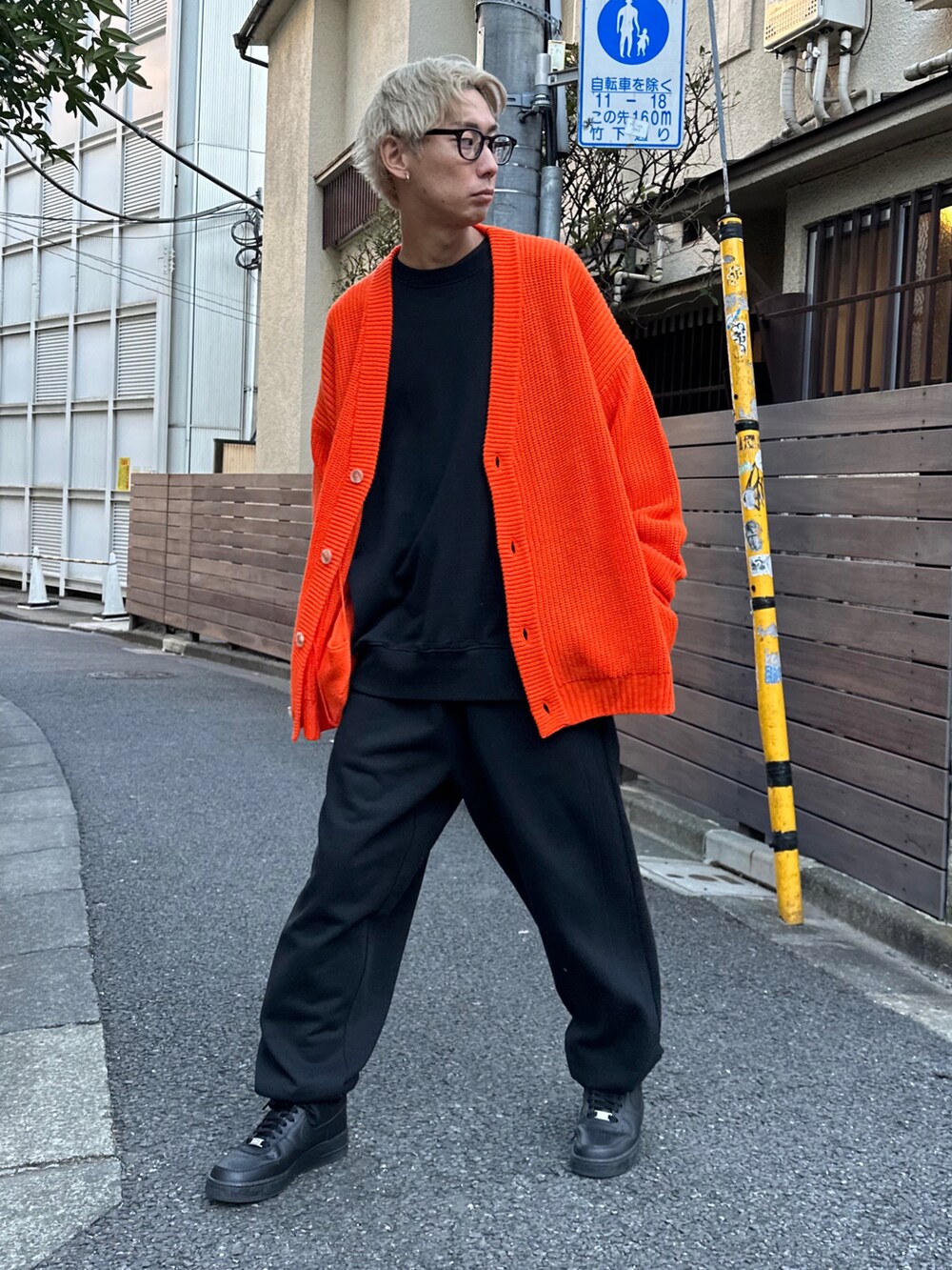オレンジ系のカーディガン/ボレロ、ブラック系のスウェット、ブラック系のスウェットパンツを着用したメンズの冬コーディネートの2枚目の写真