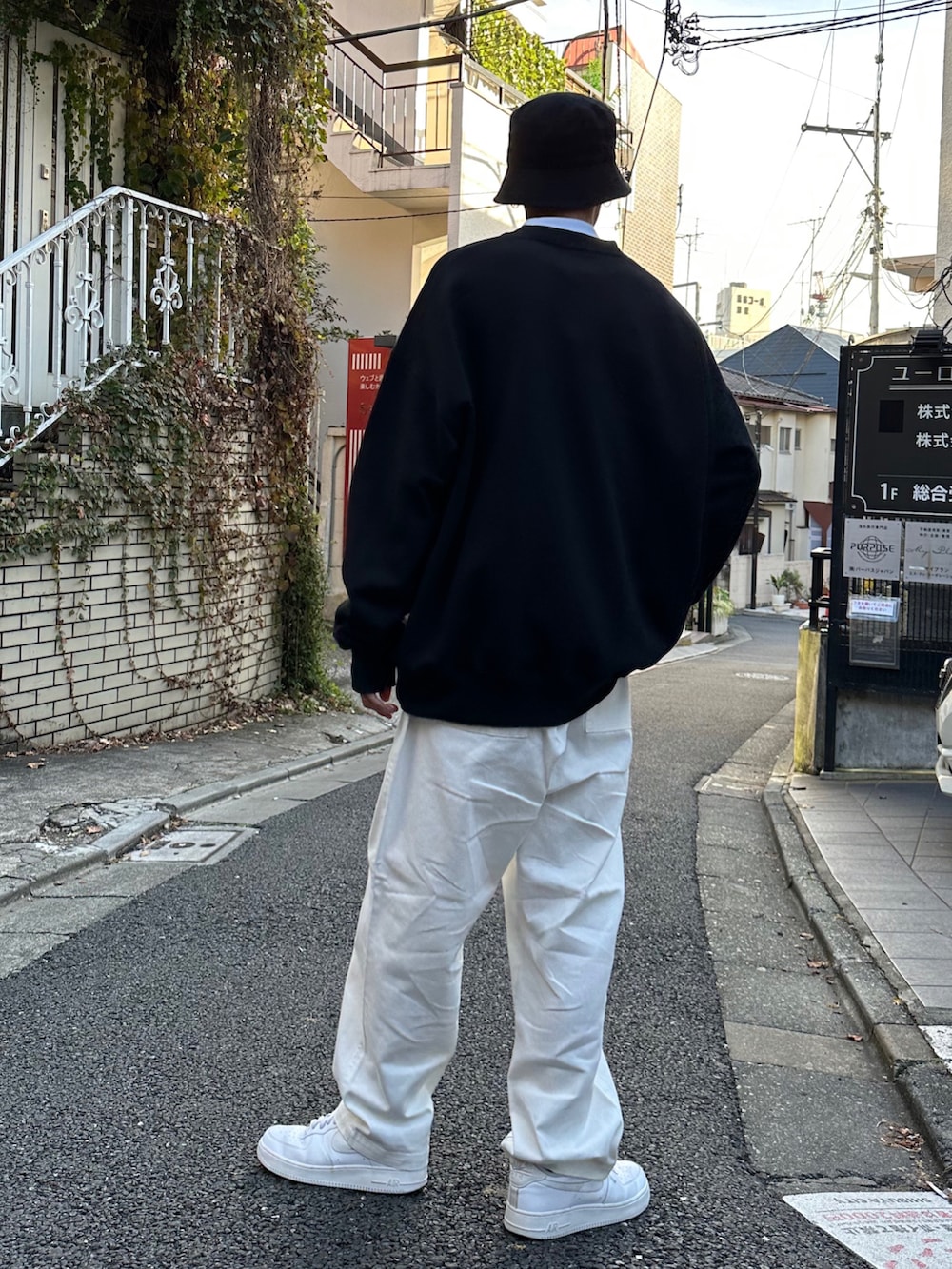 ブラック系のスウェット、ホワイト系のTシャツ/カットソー、ホワイト系のデニムパンツを着用したメンズの冬コーディネートの3枚目の写真