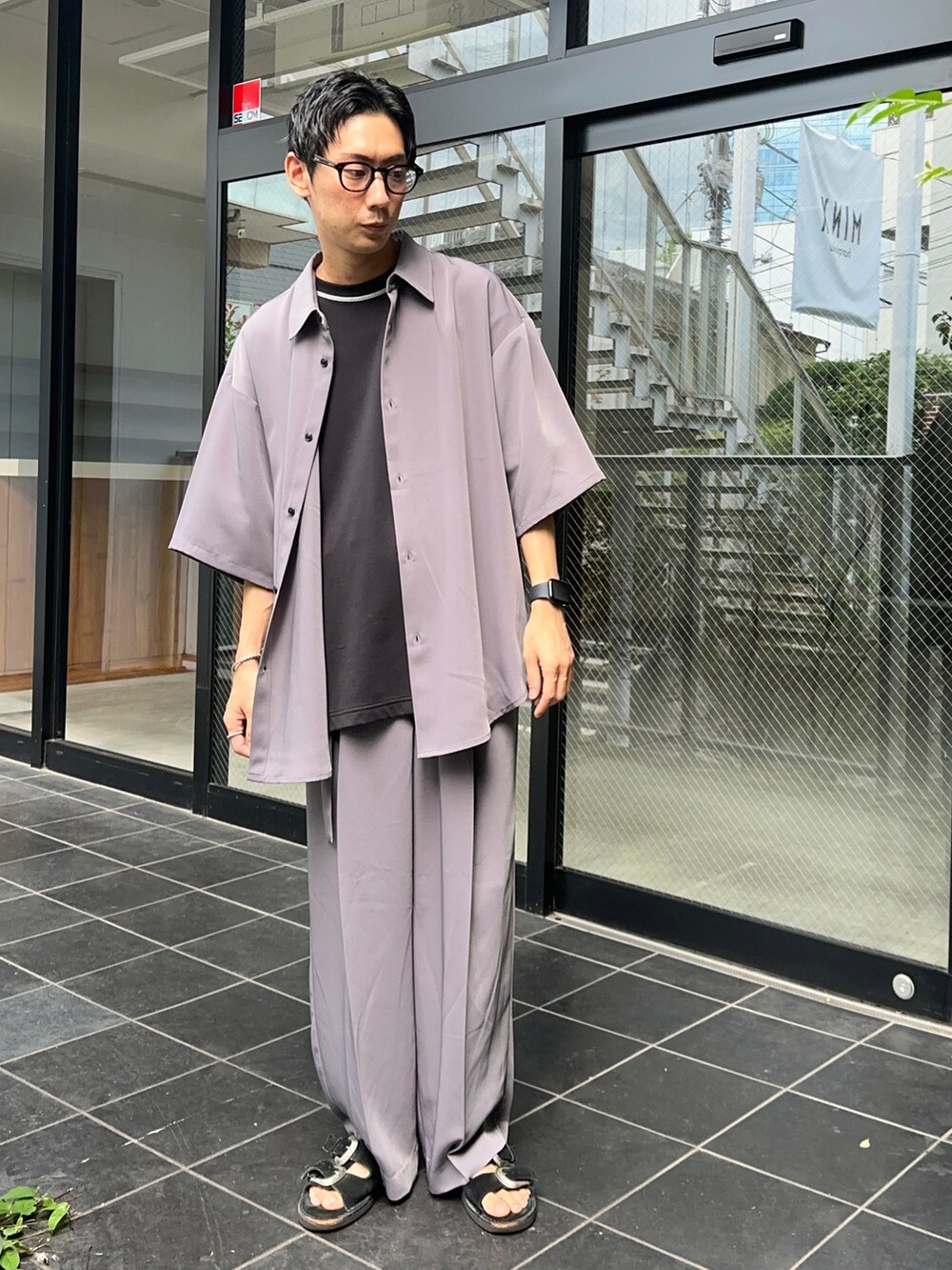 パープル系のシャツ/ブラウス、ブラック系のTシャツ/カットソー、パープル系のスラックスを着用したメンズの夏コーディネートの2枚目の写真