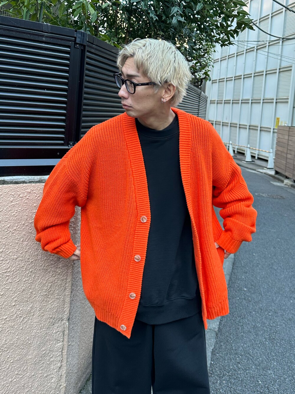 オレンジ系のカーディガン/ボレロ、ブラック系のスウェット、ブラック系のスウェットパンツを着用したメンズの冬コーディネートの4枚目の写真