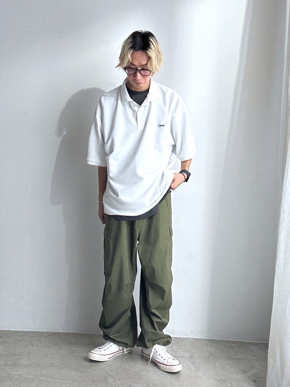 ホワイト系のポロシャツ、グレー系のTシャツ/カットソー、グリーン系のカーゴパンツを着用したメンズの春コーディネートの3枚目の写真