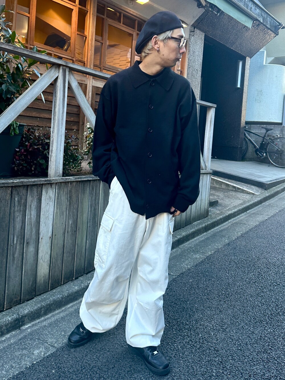 ブラック系のカーディガン/ボレロ、ホワイト系のカーゴパンツ、ブラック系のスニーカーを着用したメンズの冬コーディネートの2枚目の写真