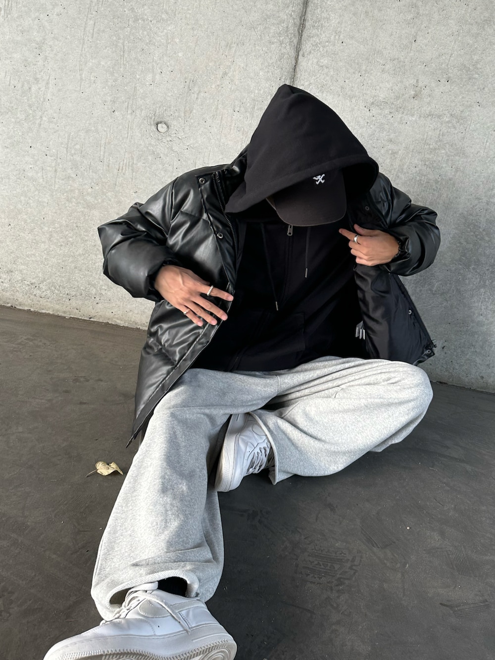 ブラック系のダウンジャケット/コート、ブラック系のパーカー、ホワイト系のTシャツ/カットソーを着用したメンズの秋コーディネートの5枚目の写真