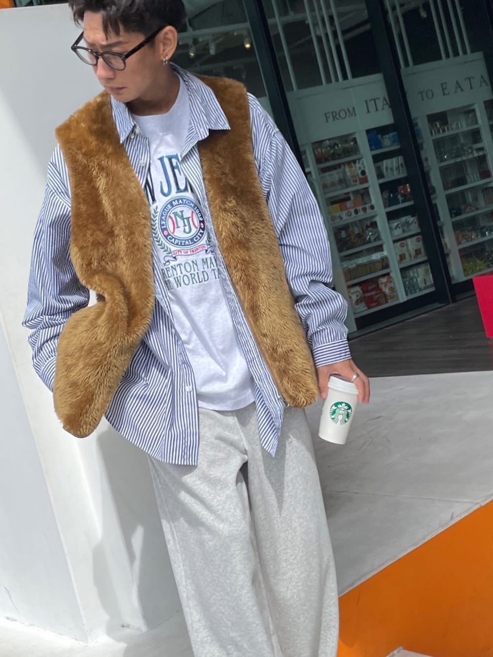 ブラウン系のベスト、ブルー系のシャツ/ブラウス、グレー系のTシャツ/カットソーを着用したメンズの秋コーディネートの2枚目の写真