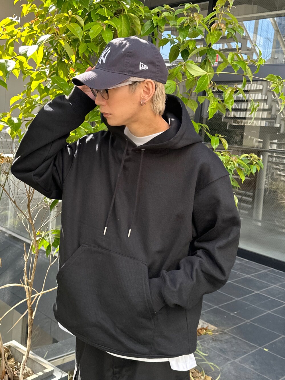 ブラック系のパーカー、ホワイト系のTシャツ/カットソー、ブラック系のカーゴパンツを着用したメンズの冬コーディネートの4枚目の写真