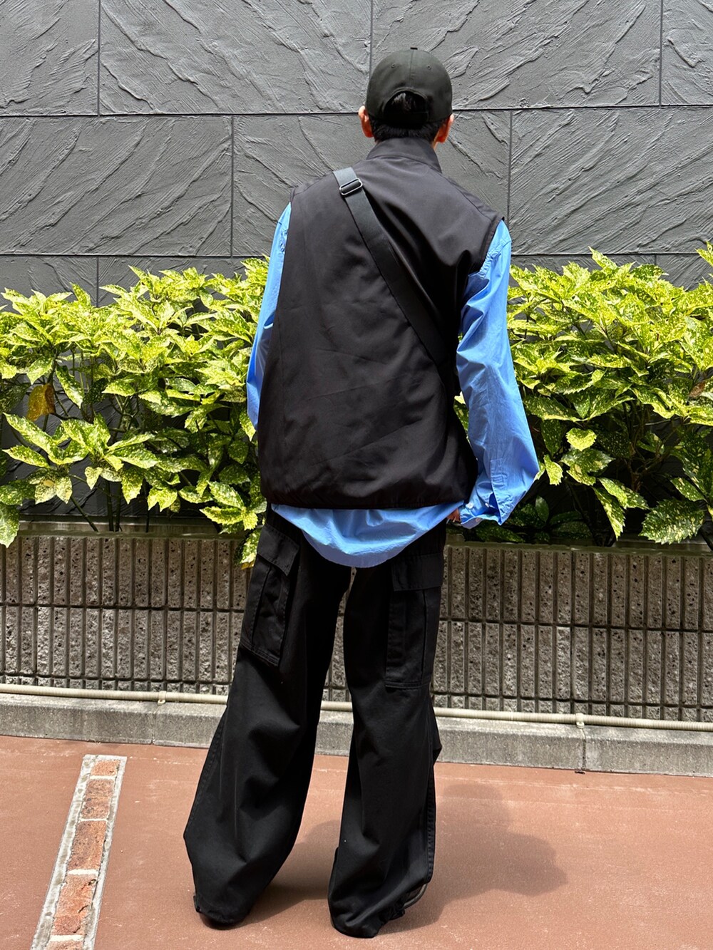 ブラック系のベスト、ブルー系のシャツ/ブラウス、ブラック系のカーゴパンツを着用したメンズの夏コーディネートの3枚目の写真