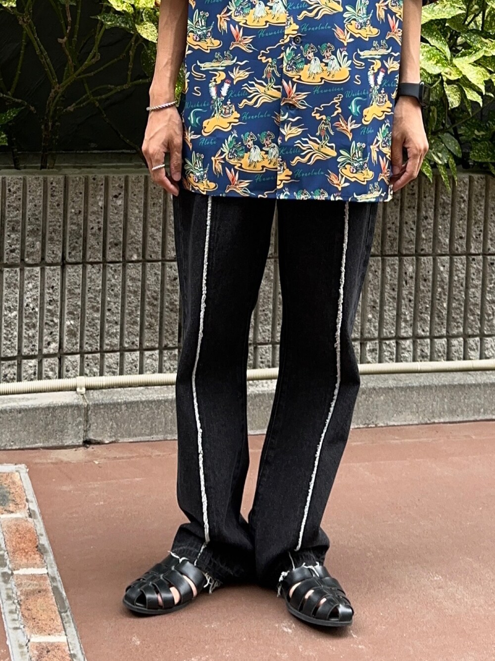 ブラック系のサンダル、ホワイト系のタンクトップ、ブラック系のデニムパンツを着用したメンズの夏コーディネートの5枚目の写真