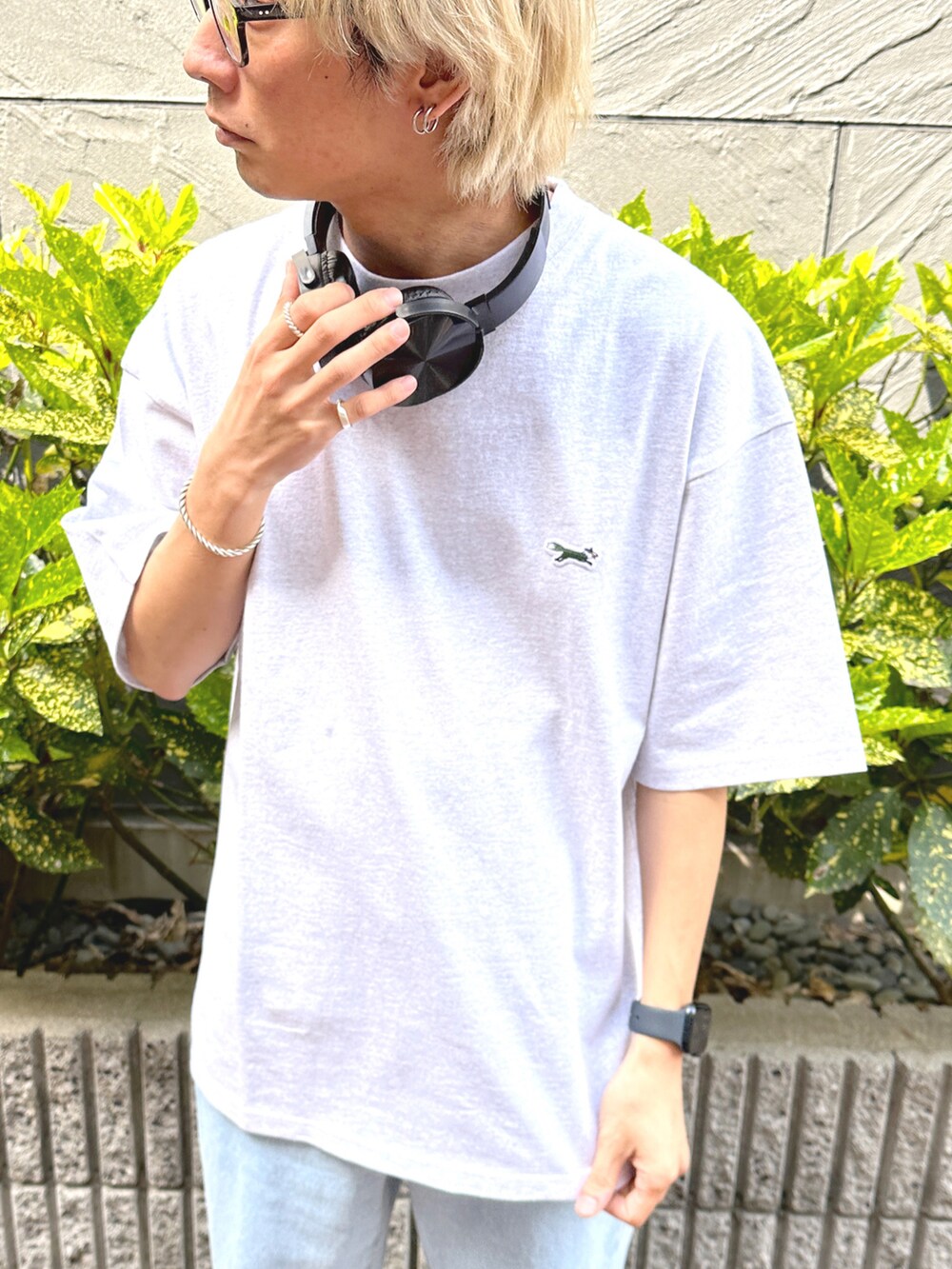 ブルー系のデニムパンツ、ホワイト系のスニーカー、グレー系のTシャツ/カットソーを着用したメンズの春コーディネートの5枚目の写真