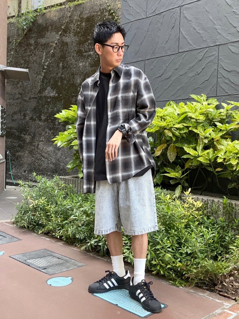 ブラック系のシャツ/ブラウス、ブラック系のTシャツ/カットソー、ブルー系のデニムパンツを着用したメンズの春コーディネートの2枚目の写真