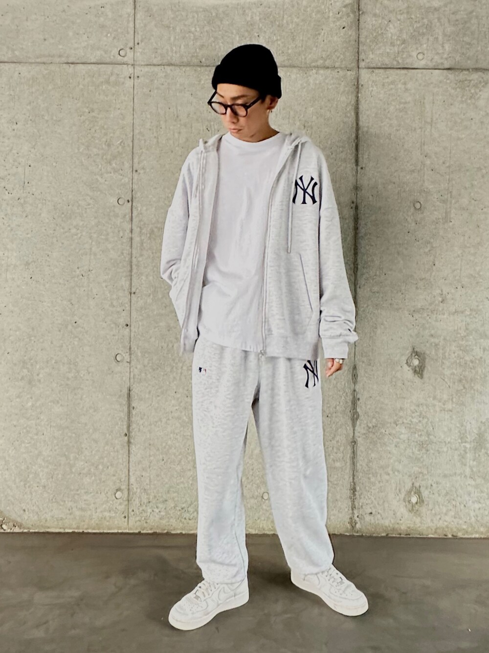 グレー系のパーカー、ホワイト系のTシャツ/カットソー、グレー系のスウェットパンツを着用したメンズの秋コーディネートの2枚目の写真