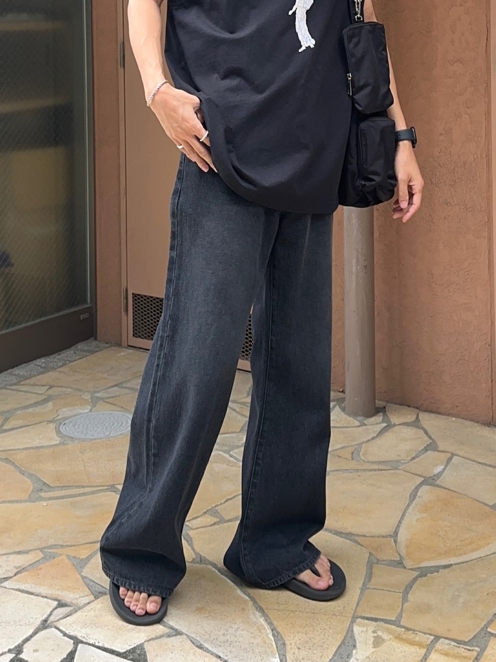 その他のタンクトップ、ブラック系のデニムパンツ、ブラック系のショルダーバッグを着用したメンズの夏コーディネートの5枚目の写真