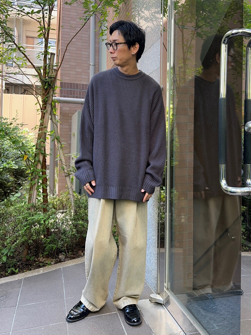 レッド系のデニムパンツ、グレー系のニット/セーターを着用したメンズの夏コーディネートの2枚目の写真