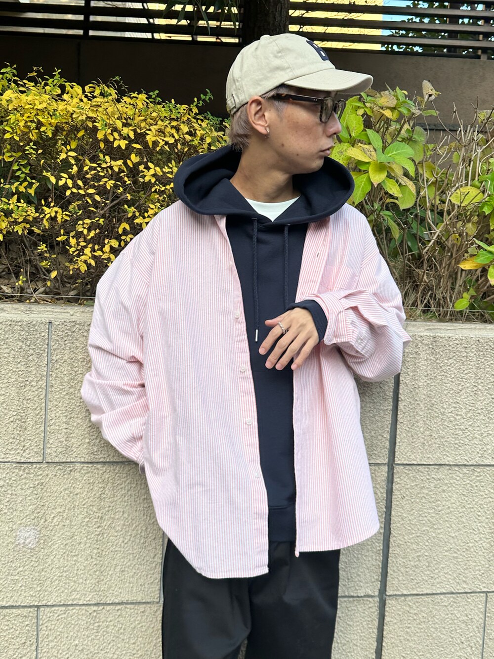 オレンジ系のシャツ/ブラウス、ブルー系のパーカー、ブラック系のチノパンツを着用したメンズの冬コーディネートの3枚目の写真