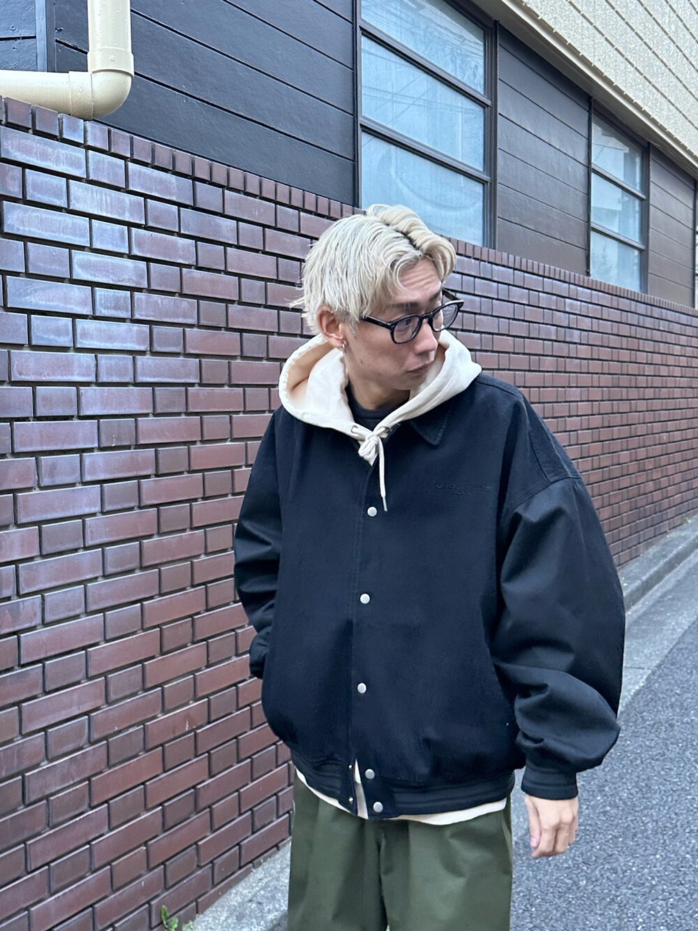 ブラック系のスタジャン、ベージュ系のパーカー、グリーン系のカーゴパンツを着用したメンズの冬コーディネートの4枚目の写真