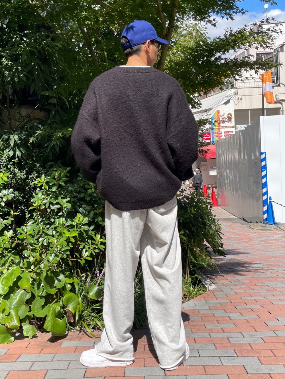 ブラック系のニット/セーター、グレー系のスウェットパンツ、ホワイト系のスニーカーを着用したメンズの秋コーディネートの3枚目の写真