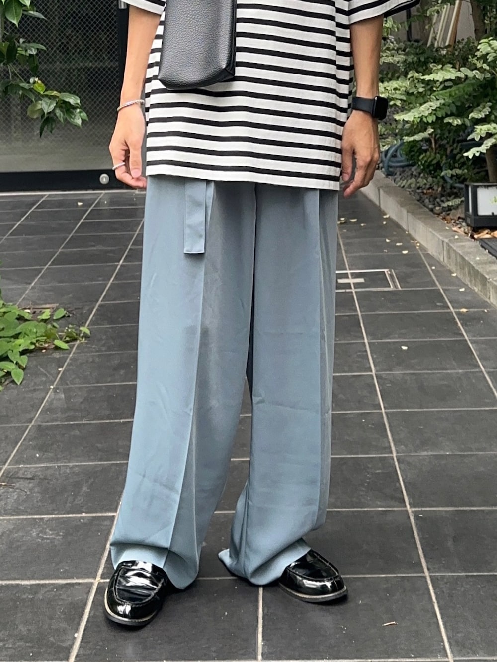 ホワイト系のTシャツ/カットソー、ブルー系のスラックスを着用したメンズの夏コーディネートの5枚目の写真
