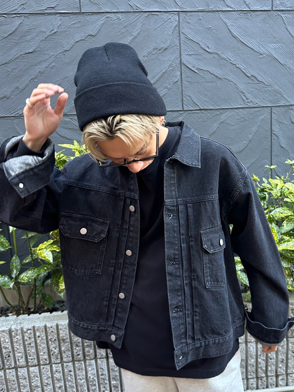 ブラック系のデニムジャケット、ブラック系のTシャツ/カットソー、ベージュ系のスウェットパンツを着用したメンズの冬コーディネートの5枚目の写真