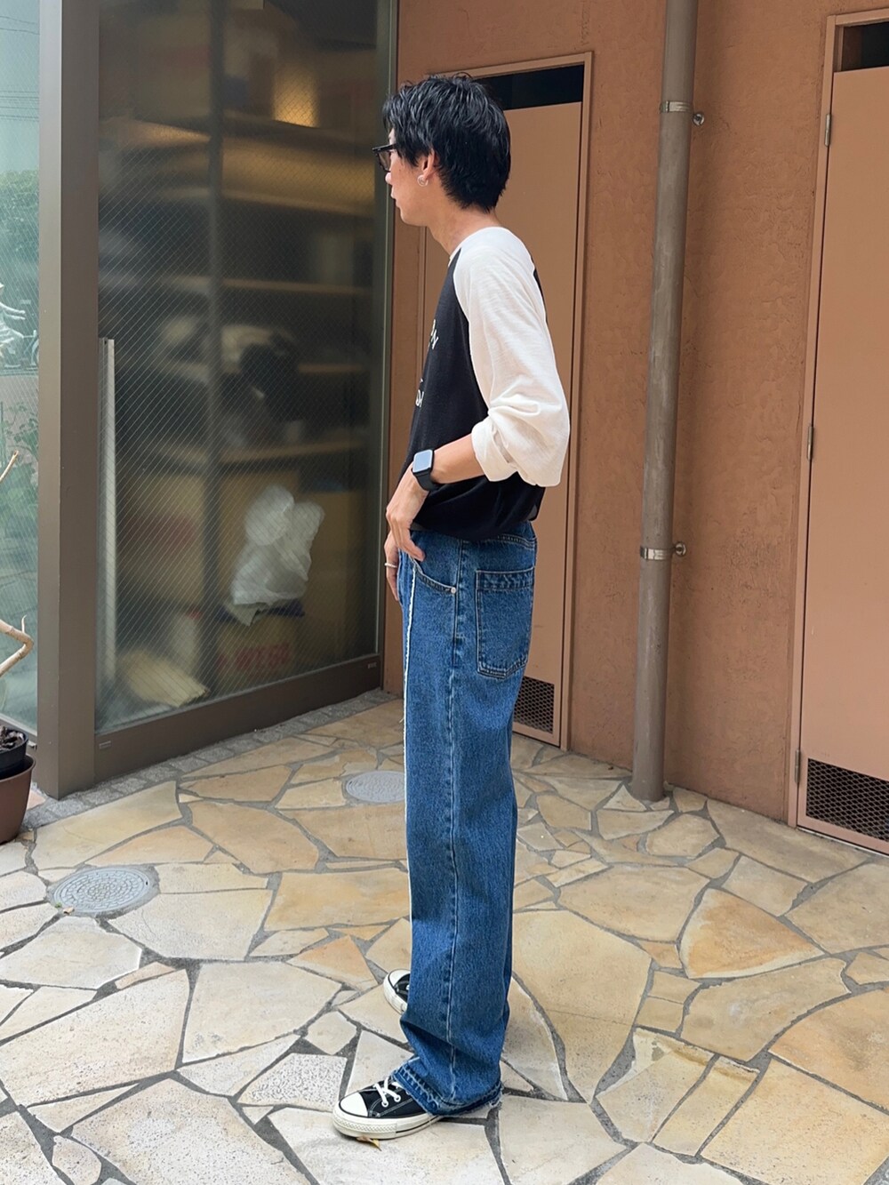 ブラック系のスニーカー、ブルー系のデニムパンツ、その他のTシャツ/カットソーを着用したメンズの夏コーディネートの2枚目の写真