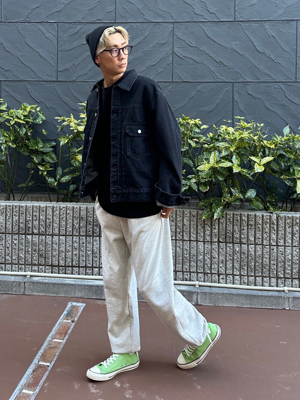 ブラック系のデニムジャケット、ブラック系のTシャツ/カットソー、ベージュ系のスウェットパンツを着用したメンズの冬コーディネートの2枚目の写真