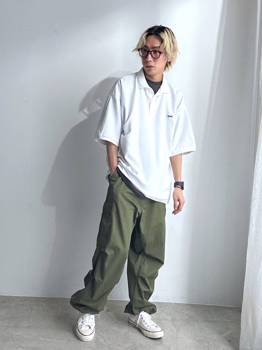 ホワイト系のポロシャツ、グレー系のTシャツ/カットソー、グリーン系のカーゴパンツを着用したメンズの春コーディネートの2枚目の写真