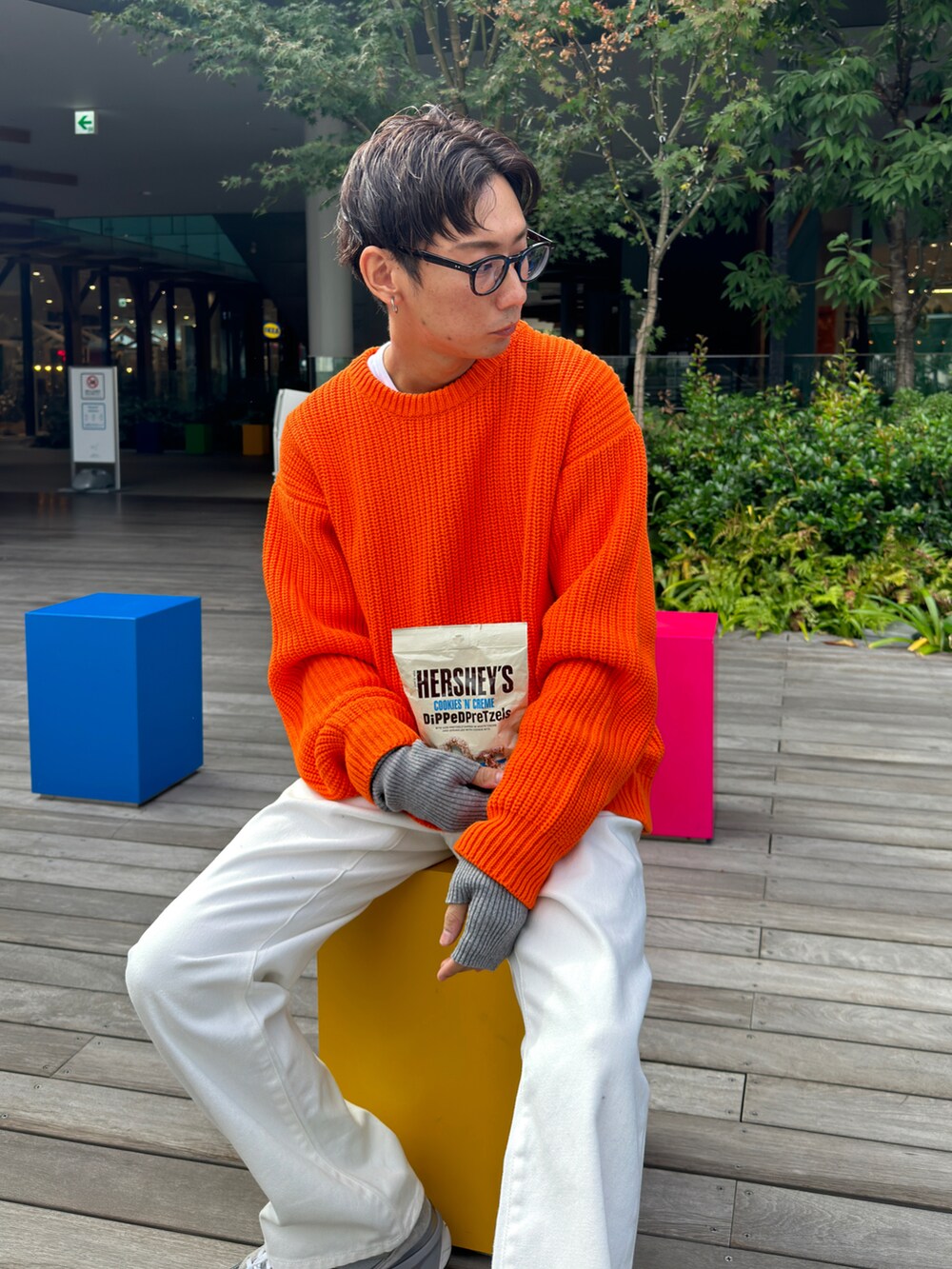 オレンジ系のニット/セーター、ホワイト系のデニムパンツ、ホワイト系のTシャツ/カットソーを着用したメンズの秋コーディネートの4枚目の写真