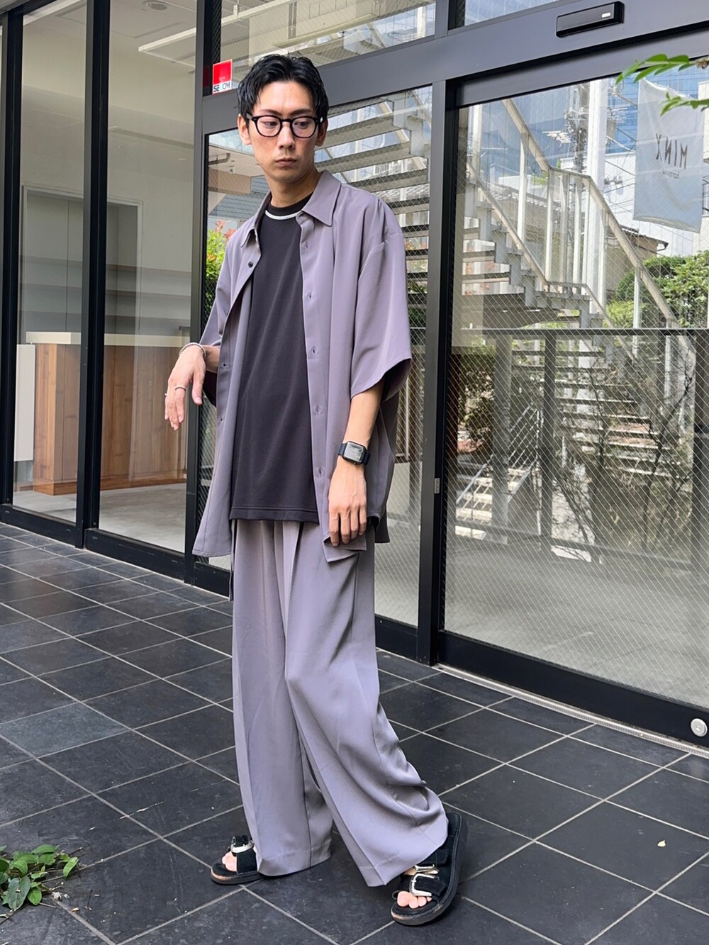 パープル系のシャツ/ブラウス、ブラック系のTシャツ/カットソー、パープル系のスラックスを着用したメンズの夏コーディネートの3枚目の写真