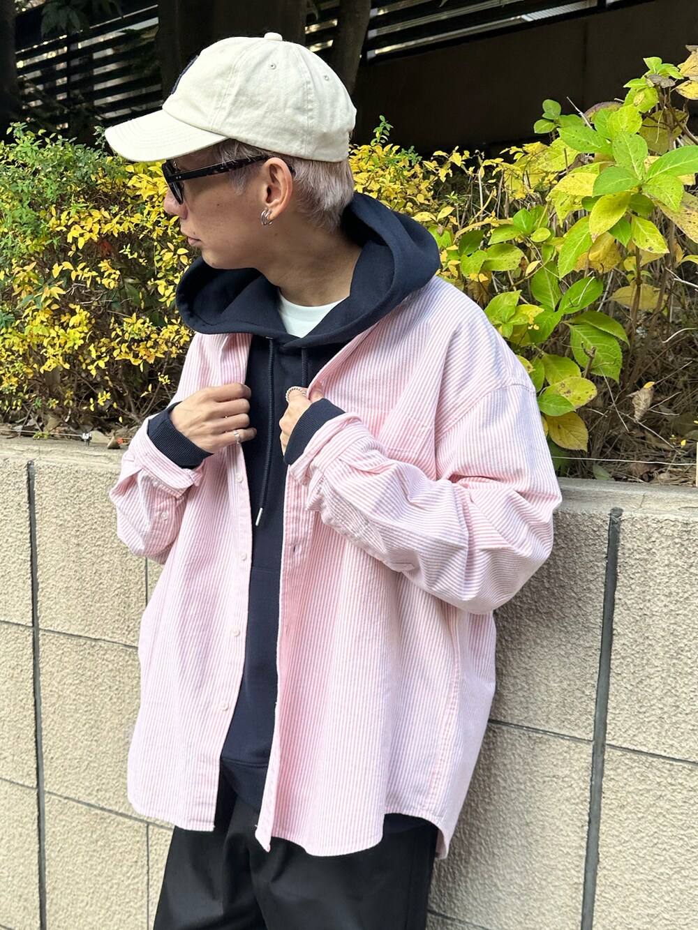 オレンジ系のシャツ/ブラウス、ブルー系のパーカー、ブラック系のチノパンツを着用したメンズの冬コーディネートの2枚目の写真