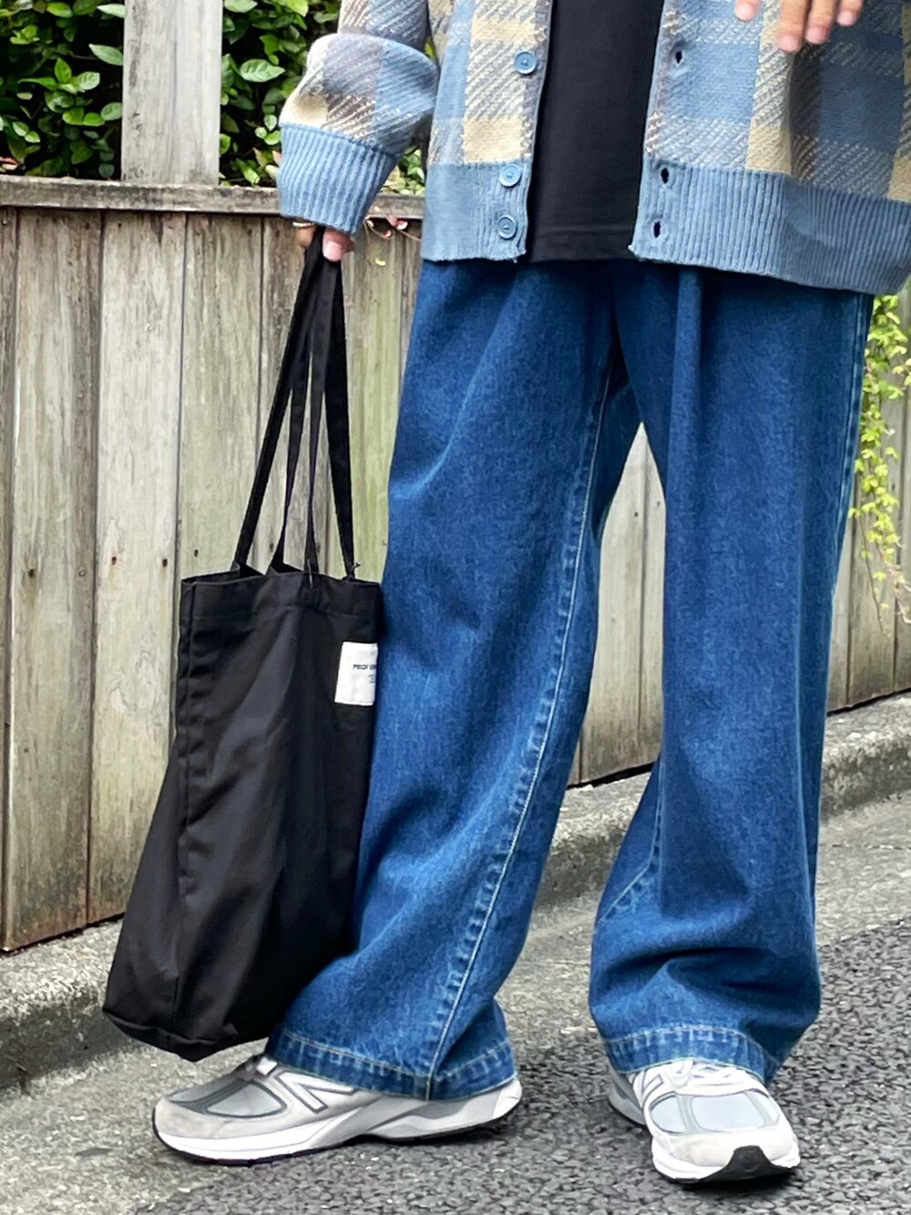 ブラック系のTシャツ/カットソー、ブルー系のチノパンツ、ブラック系のトートバッグを着用したメンズの夏コーディネートの2枚目の写真