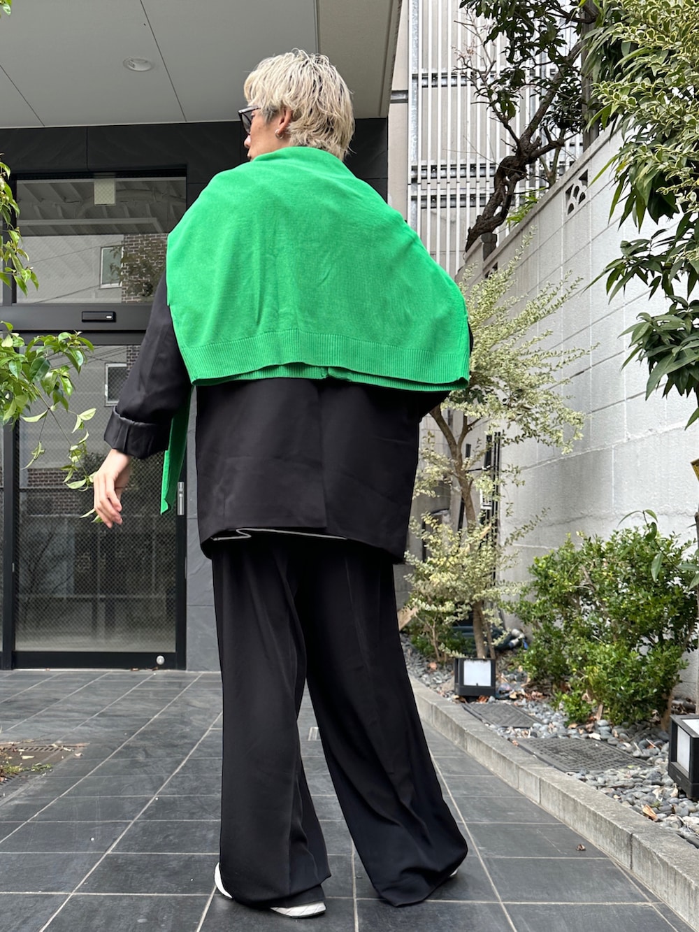 ブラック系のテーラードジャケット、ブラック系のTシャツ/カットソー、ブラック系のスラックスを着用したメンズの春コーディネートの3枚目の写真
