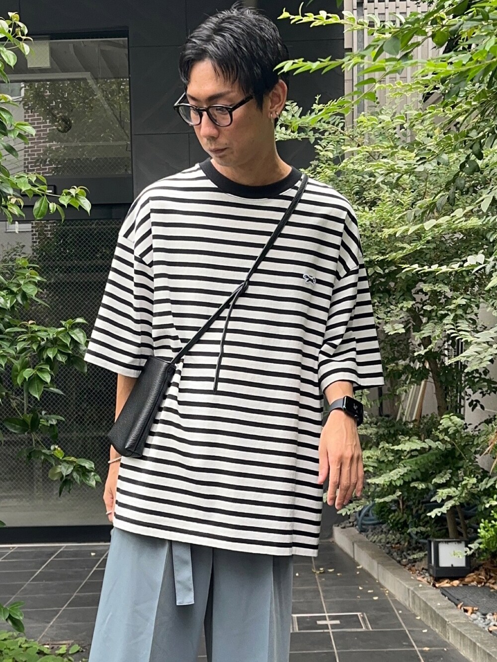 ホワイト系のTシャツ/カットソー、ブルー系のスラックスを着用したメンズの夏コーディネートの4枚目の写真