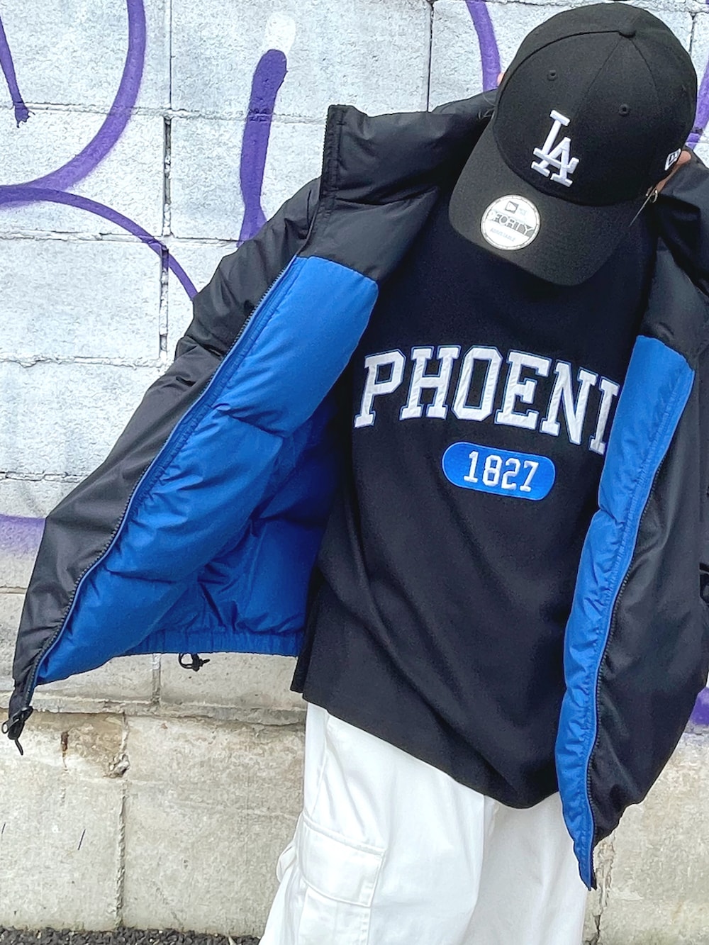 ブルー系のダウンジャケット/コート、ブラック系のTシャツ/カットソー、ホワイト系のカーゴパンツを着用したメンズの夏コーディネートの2枚目の写真