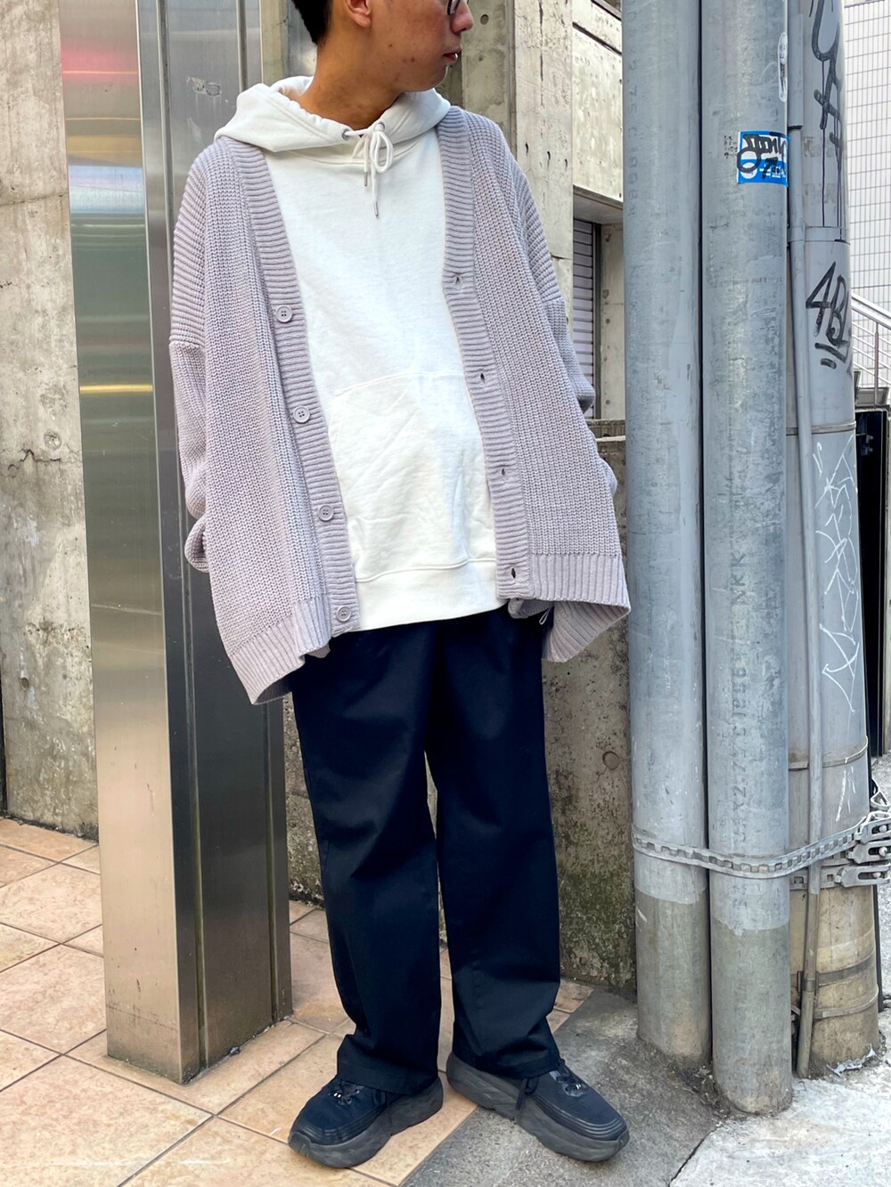 グレー系のカーディガン/ボレロ、ホワイト系のパーカー、ブラック系のチノパンツを着用したメンズの冬コーディネートの2枚目の写真