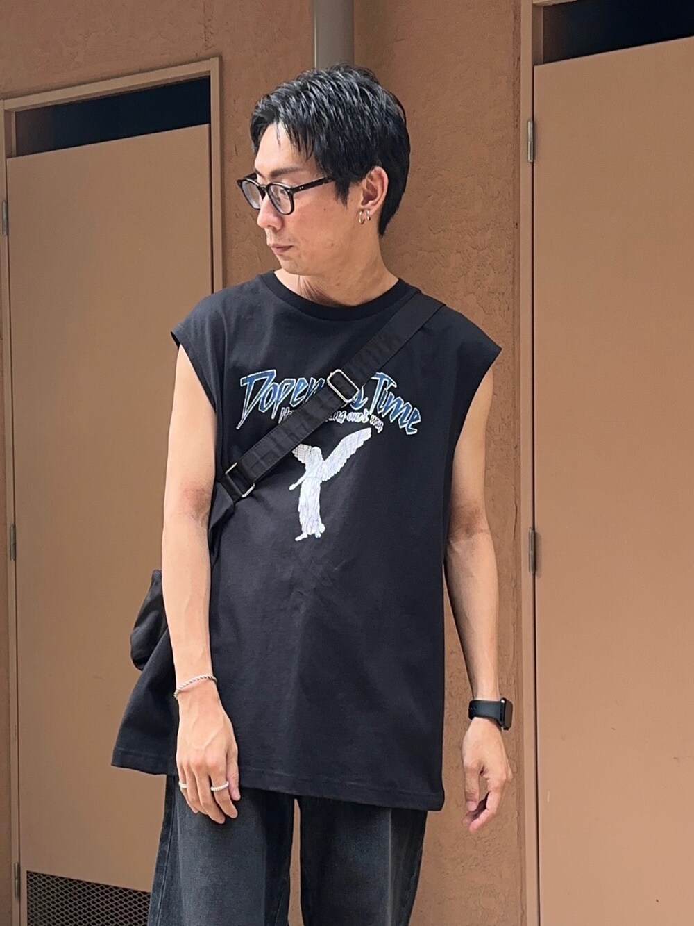 その他のタンクトップ、ブラック系のデニムパンツ、ブラック系のショルダーバッグを着用したメンズの夏コーディネートの4枚目の写真