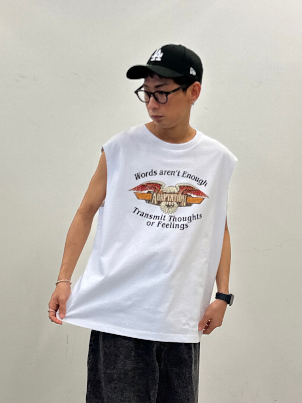 ブラック系のデニムパンツ、ブラック系のサンダル、その他のタンクトップを着用したメンズの夏コーディネートの2枚目の写真