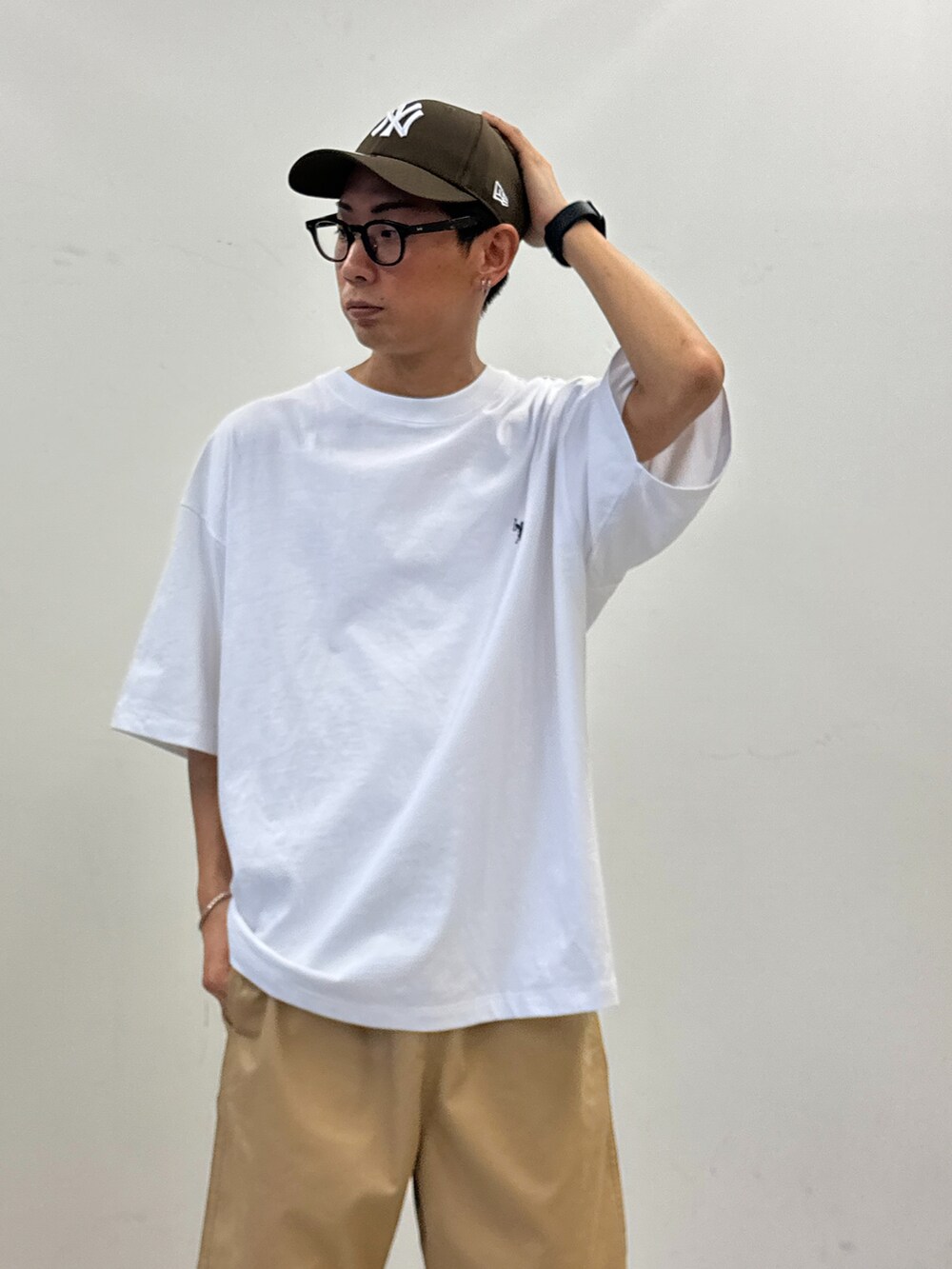 ホワイト系のTシャツ/カットソー、ベージュ系のチノパンツ、ベージュ系のショルダーバッグを着用したメンズの春コーディネートの4枚目の写真