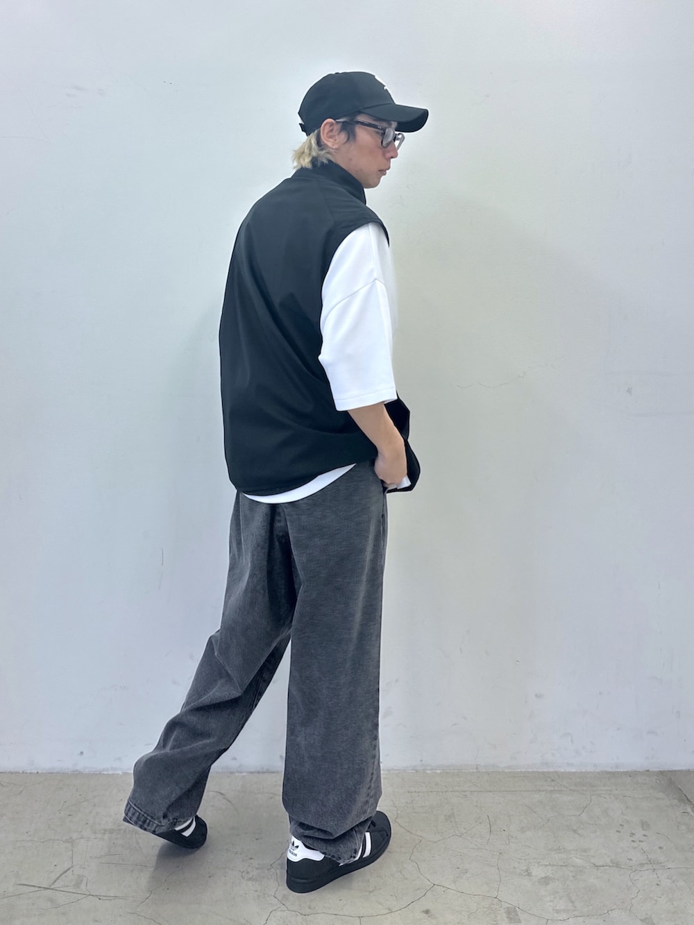 ホワイト系のTシャツ/カットソー、ブラック系のベスト、ブラック系のデニムパンツを着用したメンズの春コーディネートの3枚目の写真