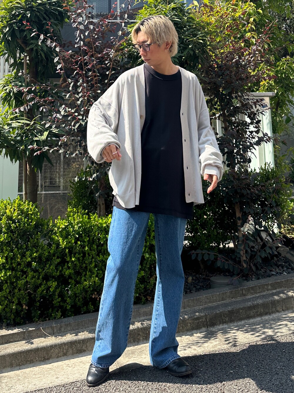 グレー系のカーディガン/ボレロ、ブラック系のTシャツ/カットソー、ブルー系のデニムパンツを着用したメンズの春コーディネートの2枚目の写真