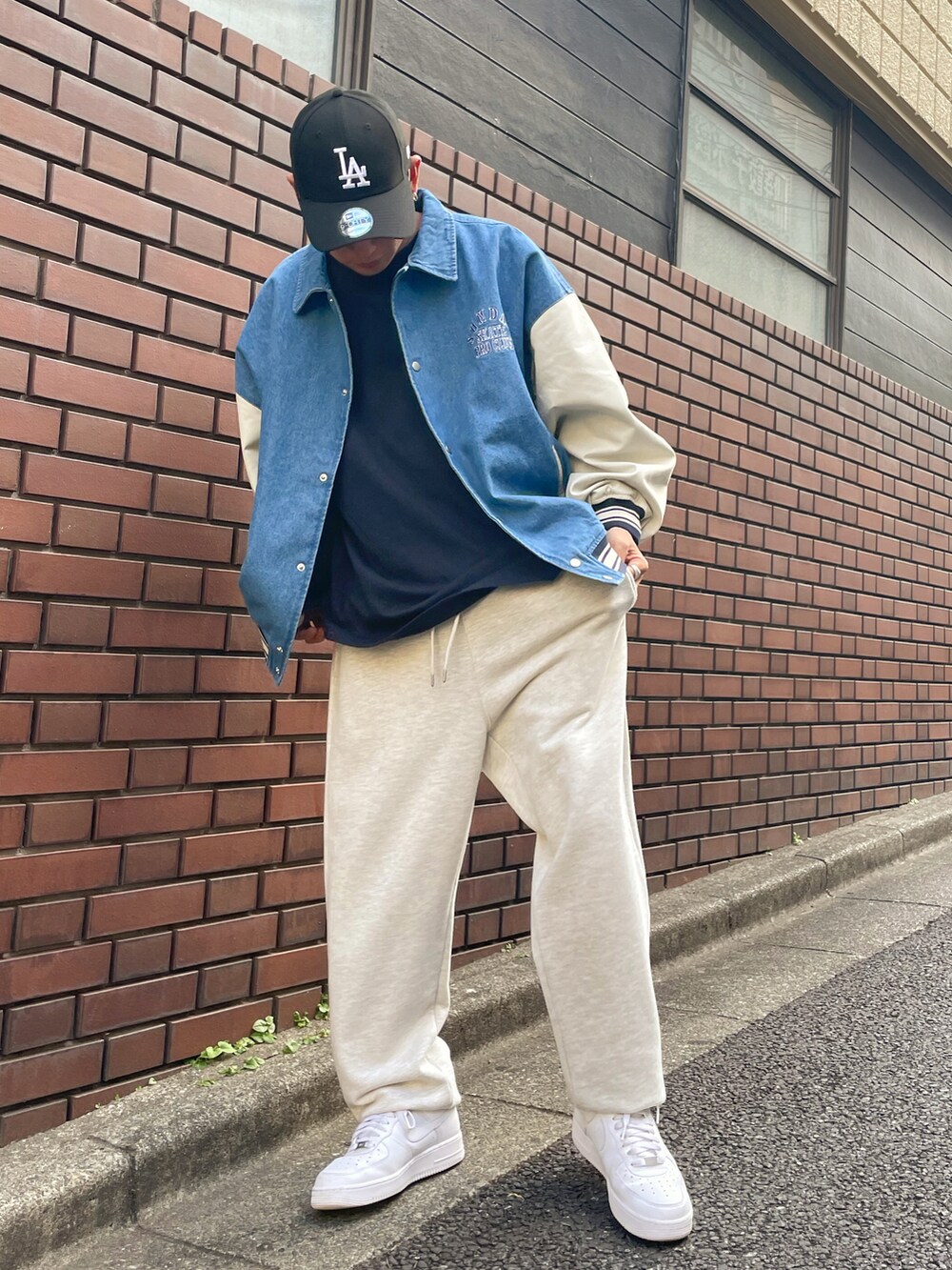 ブルー系のスタジャン、グレー系のスウェットパンツ、ホワイト系のスニーカーを着用したメンズの夏コーディネートの2枚目の写真