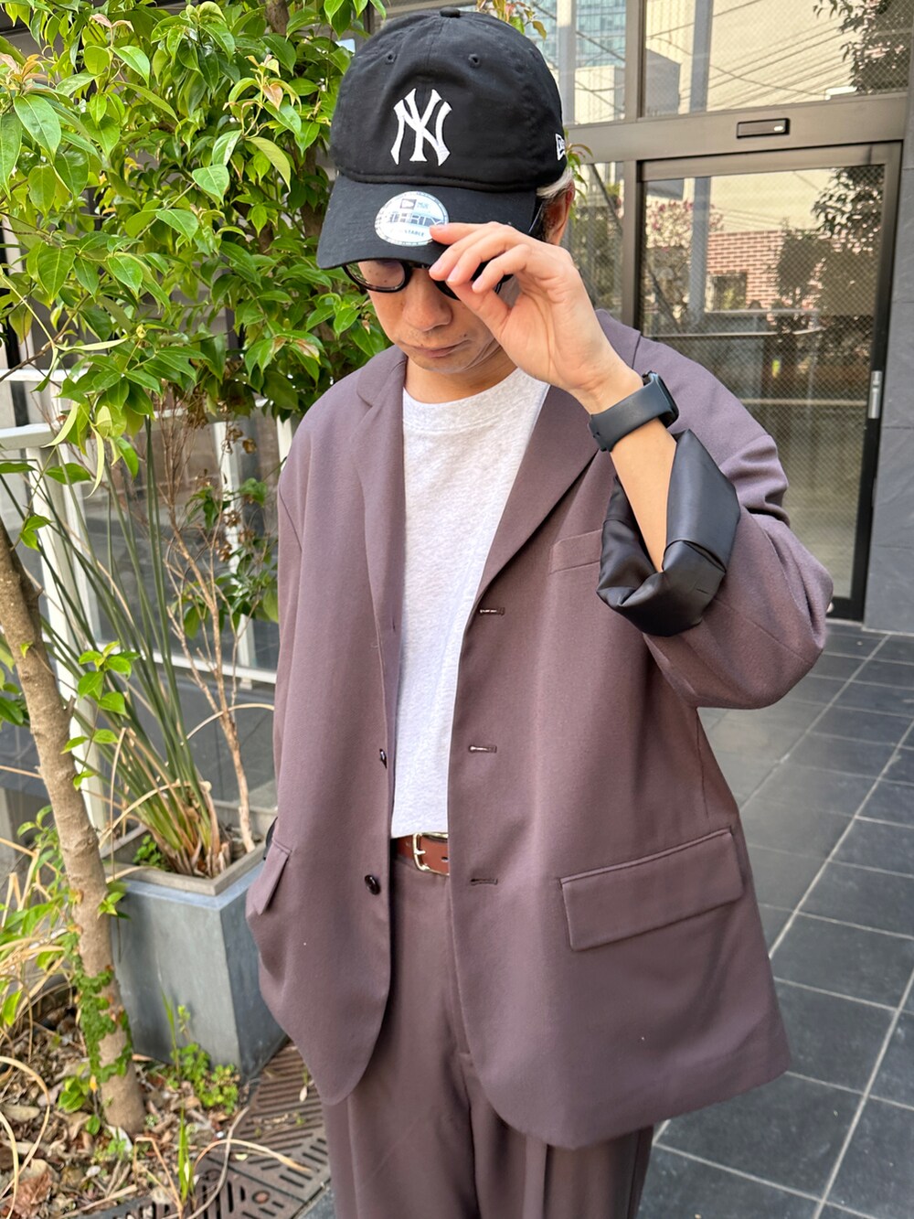 ブラック系のテーラードジャケット、グレー系のTシャツ/カットソー、ホワイト系のスニーカーを着用したメンズの春コーディネートの4枚目の写真