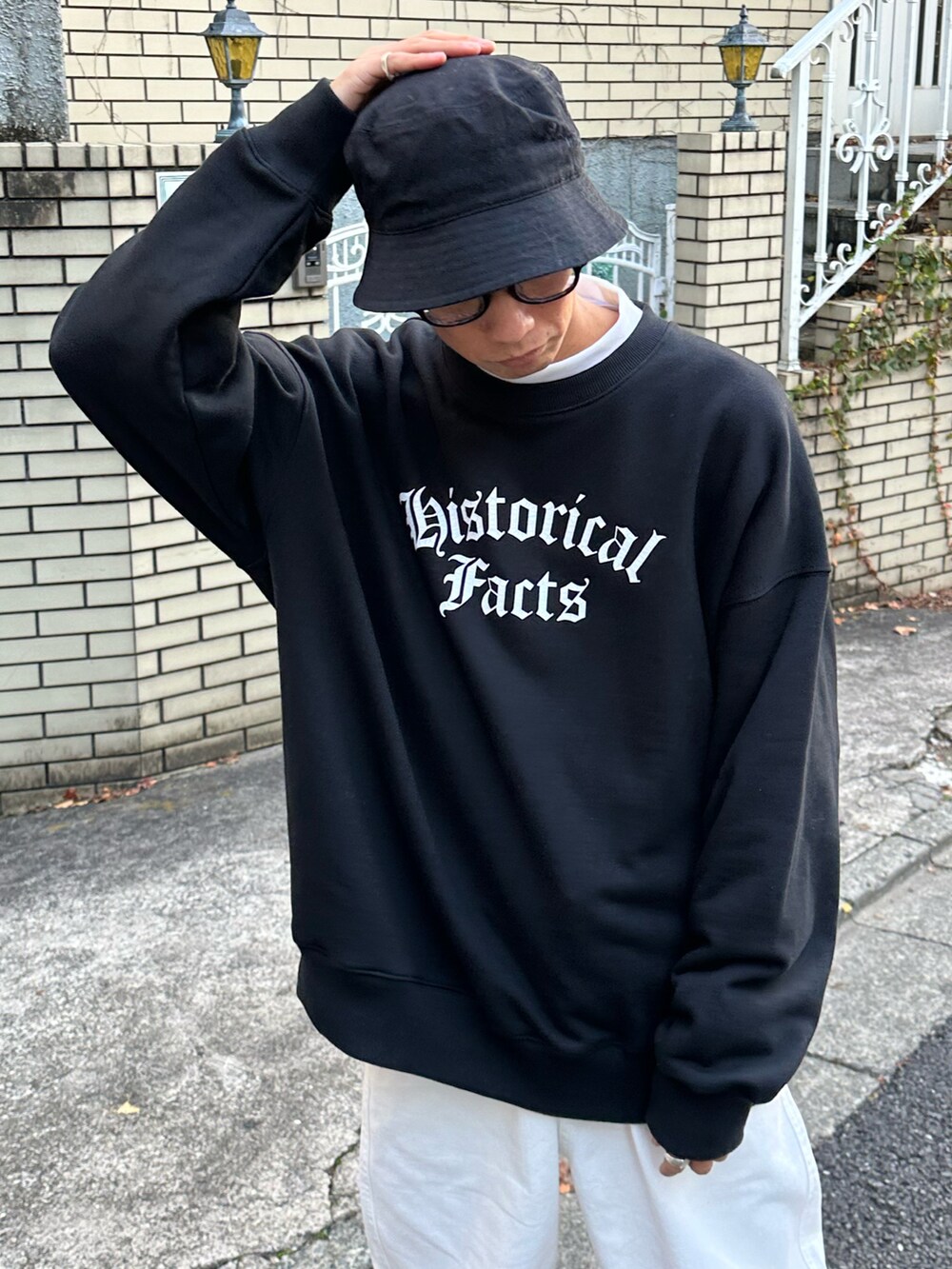ブラック系のスウェット、ホワイト系のTシャツ/カットソー、ホワイト系のデニムパンツを着用したメンズの冬コーディネートの5枚目の写真