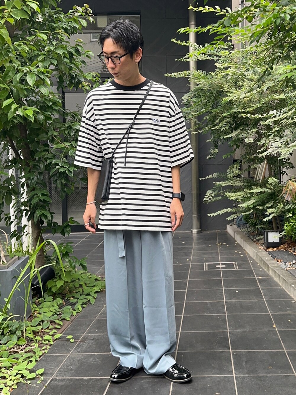 ホワイト系のTシャツ/カットソー、ブルー系のスラックスを着用したメンズの夏コーディネートの2枚目の写真