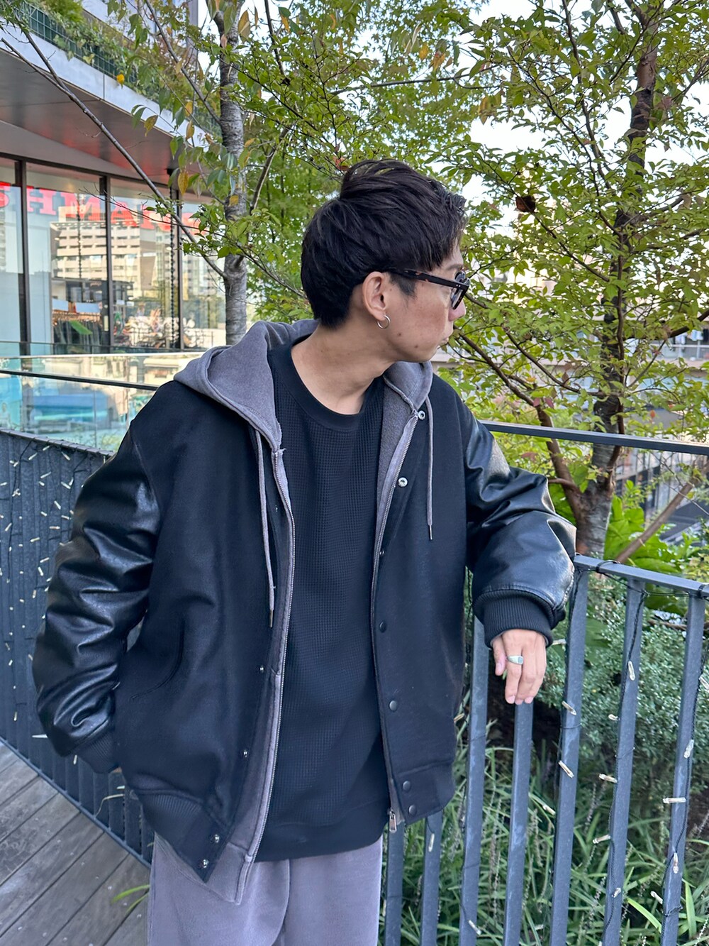 ブラック系のスタジャン、ブラウン系のパーカー、ブラック系のTシャツ/カットソーを着用したメンズの秋コーディネートの5枚目の写真