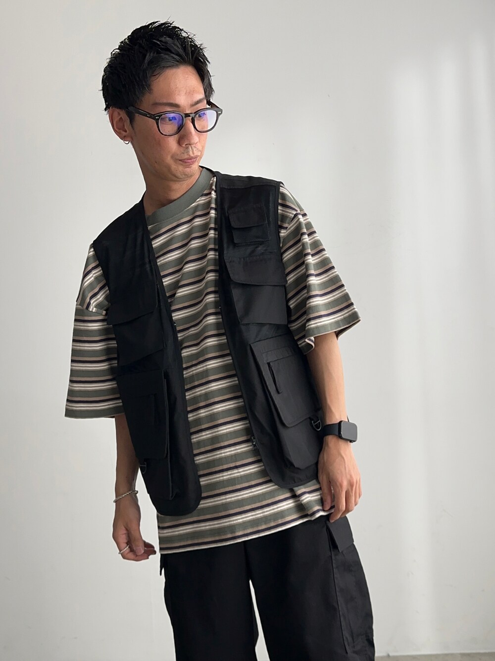 ブラック系のカーゴパンツ、ブラック系のベスト、ブラック系のスニーカーを着用したメンズの夏コーディネートの4枚目の写真