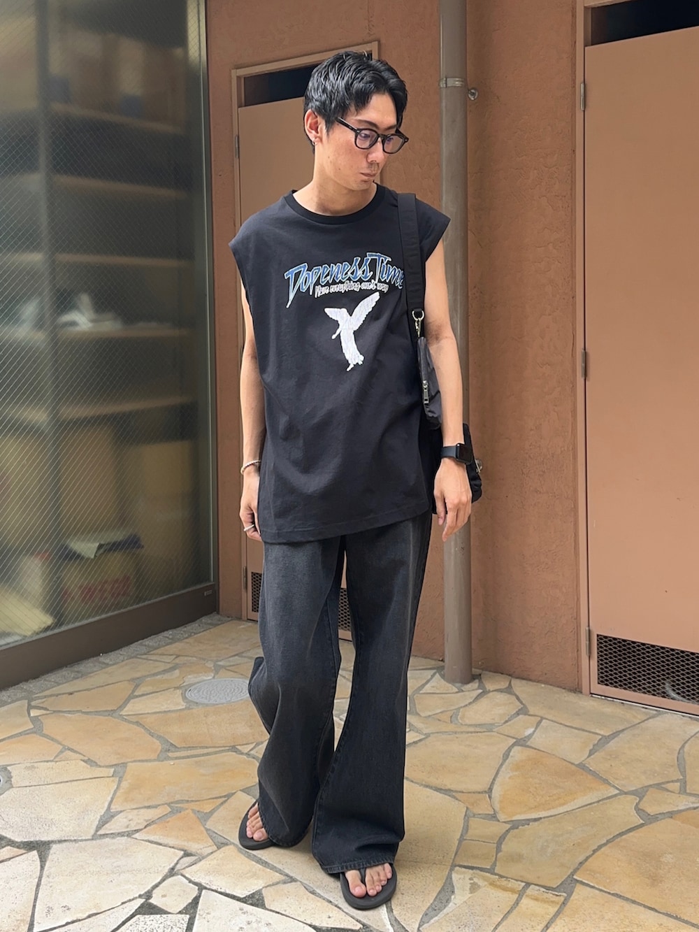 その他のタンクトップ、ブラック系のデニムパンツ、ブラック系のショルダーバッグを着用したメンズの夏コーディネートの2枚目の写真