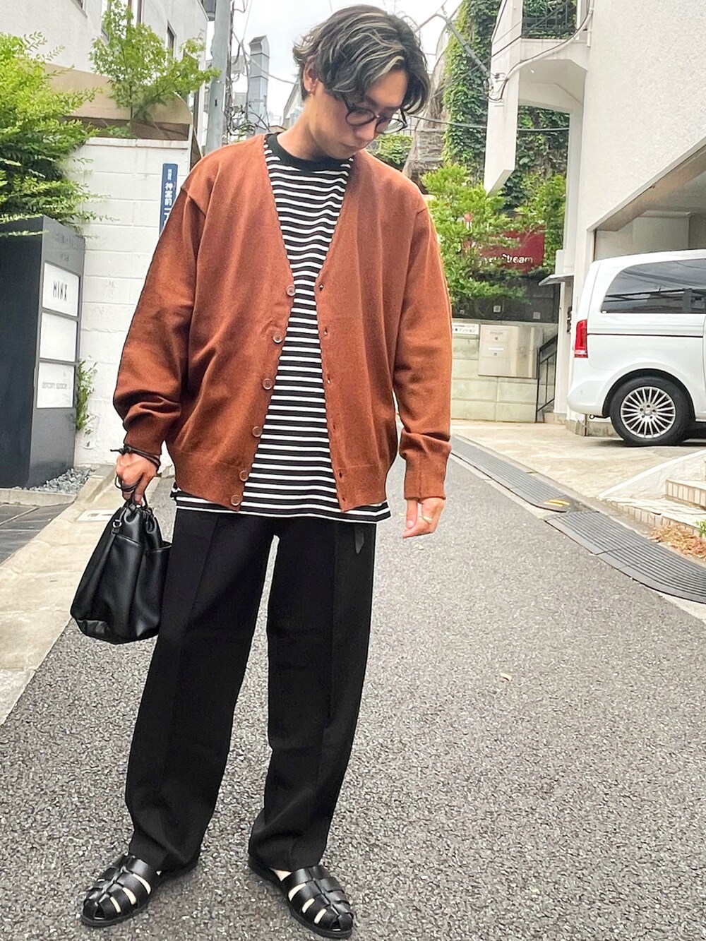 ブラック系のTシャツ/カットソー、ブラック系のスラックス、ブラック系のサンダルを着用したメンズの夏コーディネートの2枚目の写真
