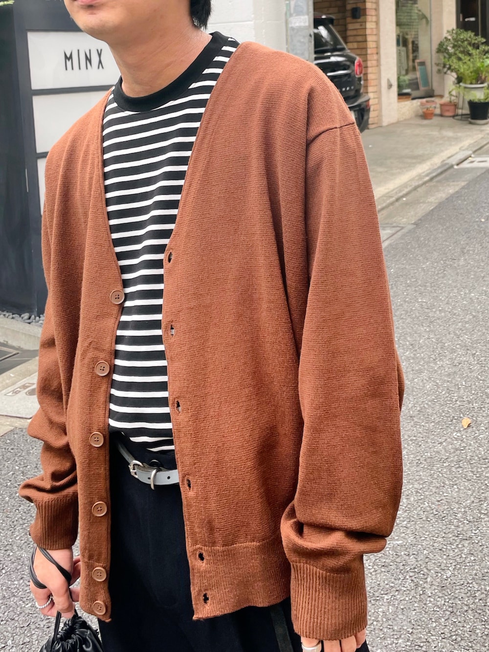 ブラック系のTシャツ/カットソー、ブラック系のスラックス、ブラック系のサンダルを着用したメンズの夏コーディネートの3枚目の写真