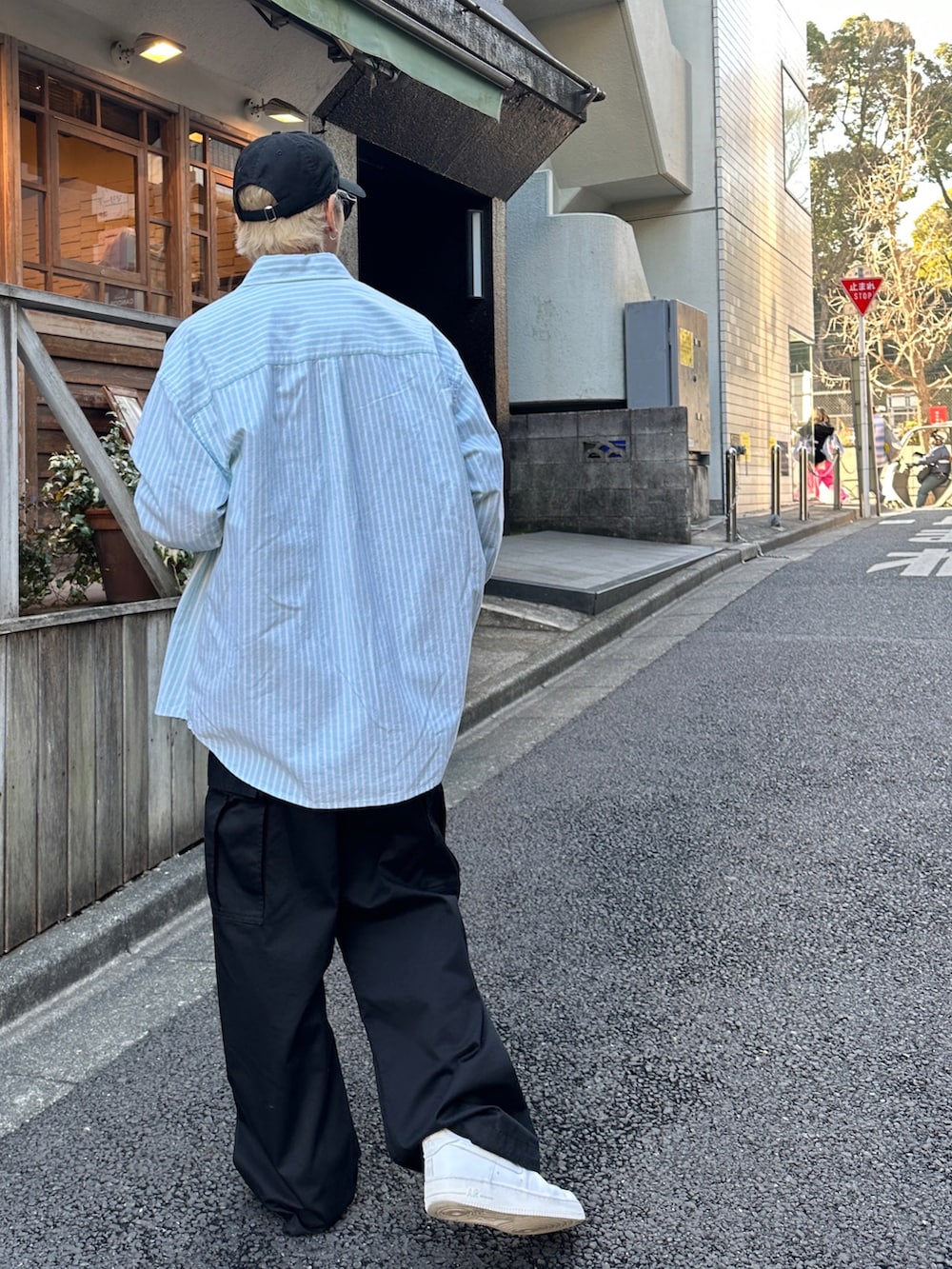 グリーン系のシャツ/ブラウス、ブラック系のスウェット、ホワイト系のスニーカーを着用したメンズの冬コーディネートの2枚目の写真