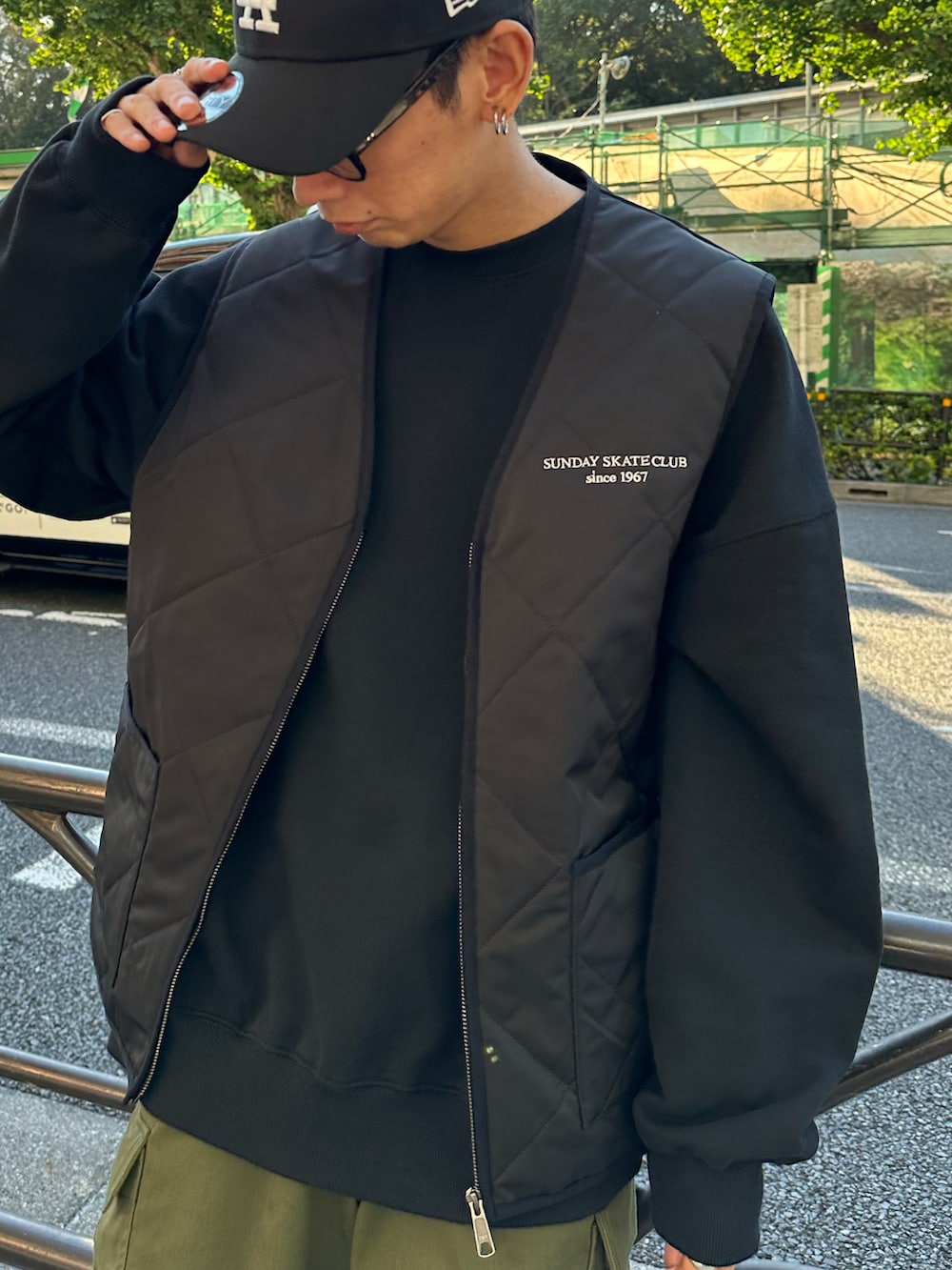 ブラック系のベスト、ブラック系のスウェット、グリーン系のカーゴパンツを着用したメンズの秋コーディネートの4枚目の写真