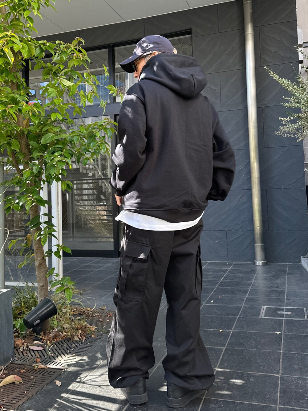 ブラック系のパーカー、ホワイト系のTシャツ/カットソー、ブラック系のカーゴパンツを着用したメンズの冬コーディネートの2枚目の写真